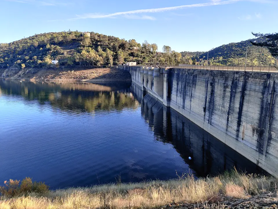 Presa y embalse con el nivel bajo y la orilla de tierra descubierta
